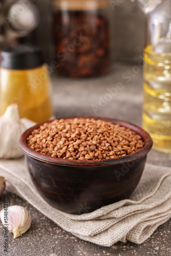 Bowl with buckwheat grains and napkin on table