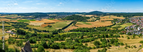 Übersicht über die mittelhessische Gemeinde Krofdorf-Gleiberg in einer Panoramaaufnahme bei sonnigem Sommerwetter mit Horizont, wolkenlosem Himmel, der Ruine der Burg Vetzberg mit ihrem Bergfried und 
