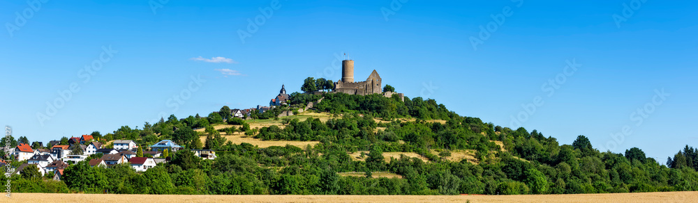 Die auf dem Gipfel eines Vulkanbergs liegende mittelalterliche Ruine der Burg Gleiberg bei sonnigen Wetter und wolkenlosem Himmel, Hessen, Deutschland