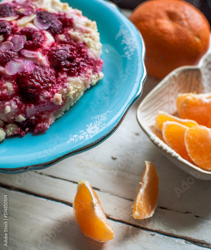 raspberry bun, sweet cake on a blue vintage cake stand with fruits,  mandarines