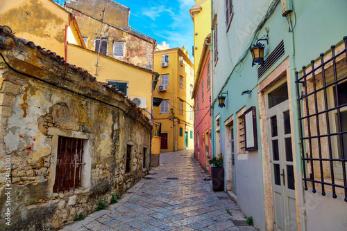 Fototapeta Naklejka Na Ścianę i Meble -  Kerkyra city narrow street view with colorful houses during sunny day. Corfu Island, Ionian Sea, Greece.
