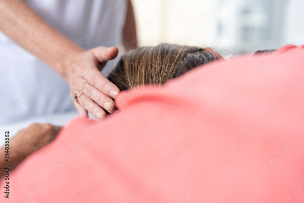 Hand of a woman touching the head of a patient during a reiki session Hand of a woman touching the head of a patient during a reiki session