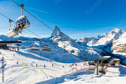 Picturesque alpine landscape with view of chairlift station of modern ski resort at foot of high rocky Matterhorn peak in canton  photo