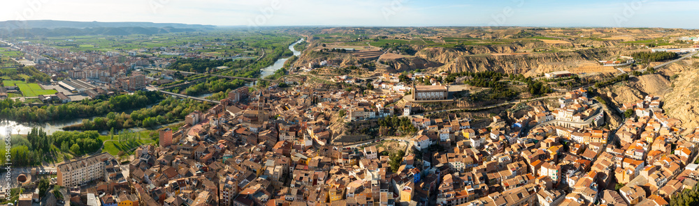 General panoramic aerial view of Spanish town of Fraga on banks of Cinca river and its surroundings on sunny day, province of Huesca, Aragon