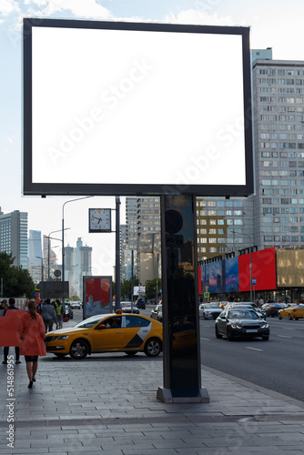 Empty billboard on paving stones against the backdrop of high-rise buildings. Mock-up.