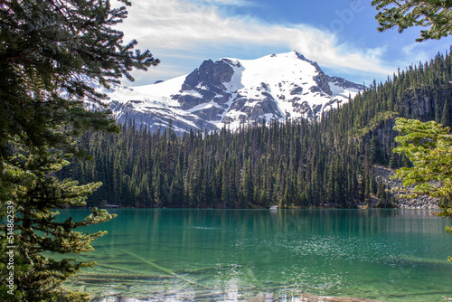 Fototapeta Naklejka Na Ścianę i Meble -  Green lake with reflection of forest and snowy mountains on the background in Joffre Lakes, BC, Canada
