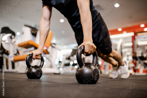 Asian young man using dumbbell Pushing up exercise at gym for good healthy in fitness, Lifestyle and sport exercise concept.