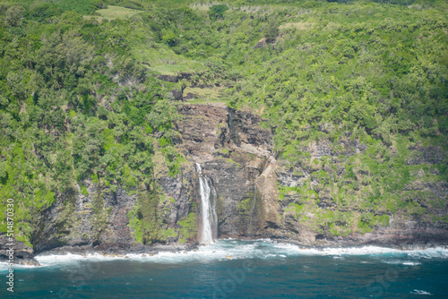 An aerial view of a waterfall spilling into the ocean on the coast of the island of Maui  Hawaii.