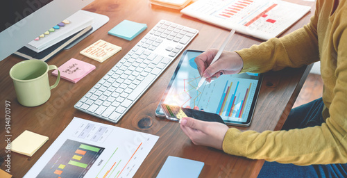 Businesswoman working at office with document on her desk, doing planning analyzing the financial report, business plan investment, finance analysis concept.Using laptop and tablet.