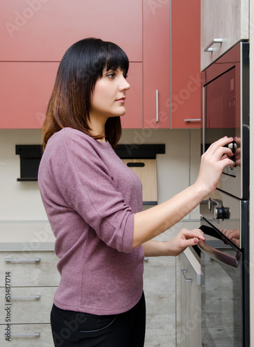 A young woman adjusts the power of a microwave oven.