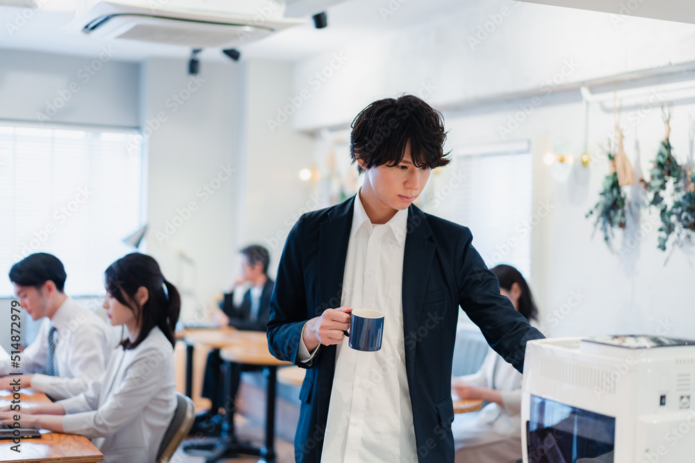 Fototapeta premium シェアオフィスでコーヒーを飲むビジネスマン