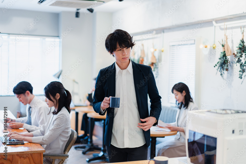 Fototapeta premium シェアオフィスでコーヒーを飲むビジネスマン