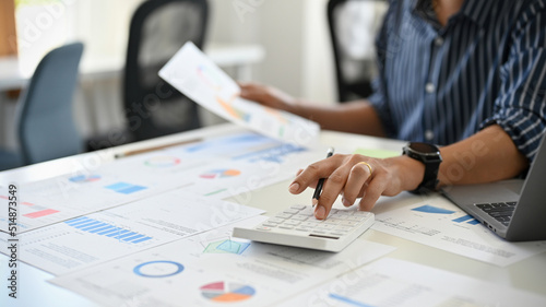 Businessman or male financial manager working at his desk, calculating