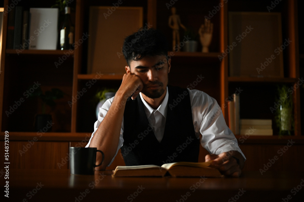 Thoughtful asian businessman focused reading some paragraph on the book