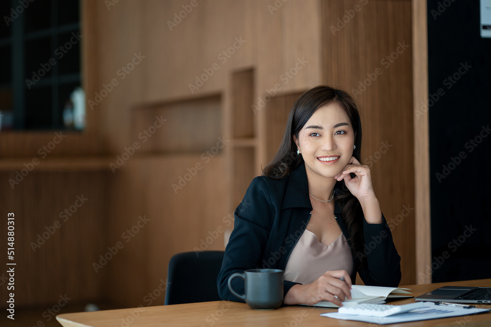 Asian businesswoman working using laptop computer in modern office Make an account analysis report with financial graphs and real estate investment data. financial and tax system concepts