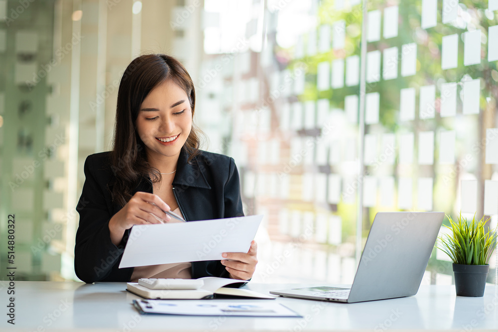 Asian businesswoman working using laptop computer in modern office Make an account analysis report with financial graphs and real estate investment data. financial and tax system concepts Asian businesswoman working using laptop computer in modern office Make an account analysis report with financial graphs and real estate investment data. financial and tax system concepts