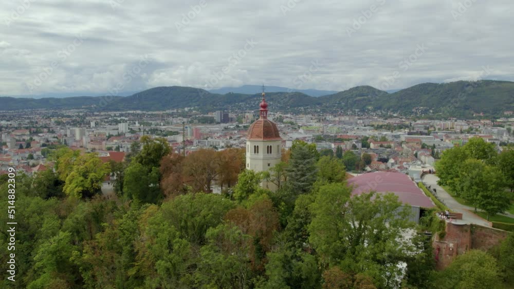 Aerial view flying away from Glockenturm tower on Graz's Schloßberg hilltop woodland park Aerial view flying away from Glockenturm tower on Graz's Schloßberg hilltop woodland park