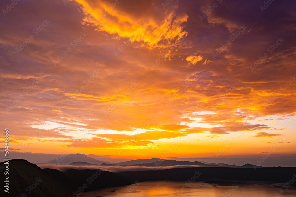 朝の光に雲が染まるドラマチックな風景。日本の北海道の摩周湖で。