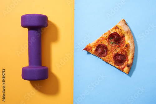 Dumbbell and pizza  on yellow and blue background , gluten free pizza for healthy diet   photo