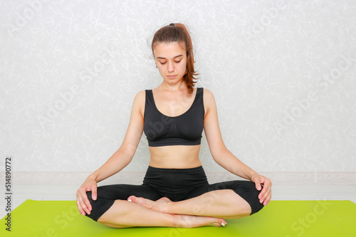 Woman beginner doing yoga. Woman doing sports at home. Yoga and meditation positions.