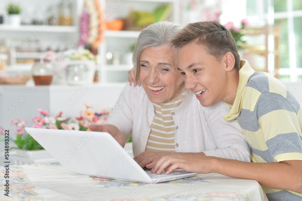 Grandmother with her grandson using laptop at home Grandmother with her grandson using laptop at home