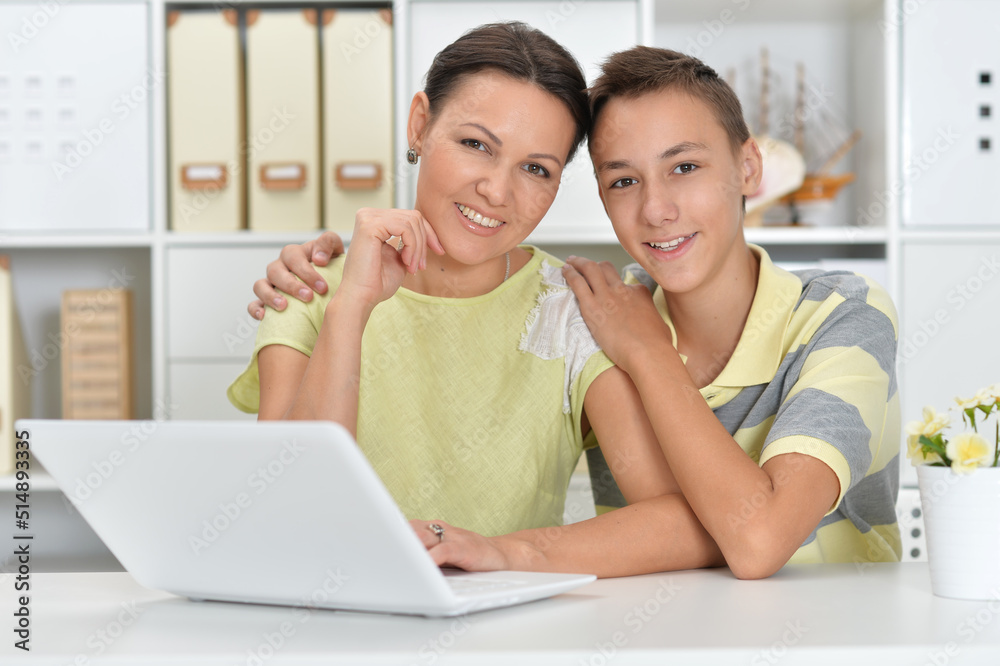 mother and son using modern laptop mother and son using modern laptop