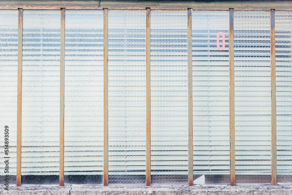 une vieille fenêtre avec une vitre opaque et un zéro rouge écrit. Des