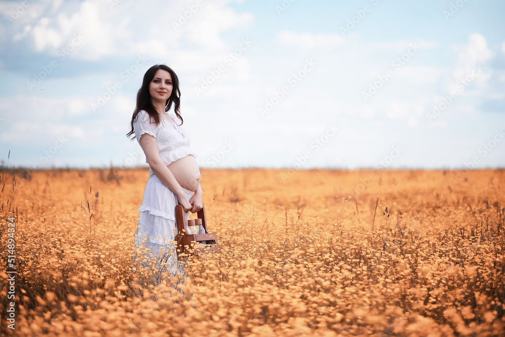 Pregnant woman in nature for a walk in the autumn