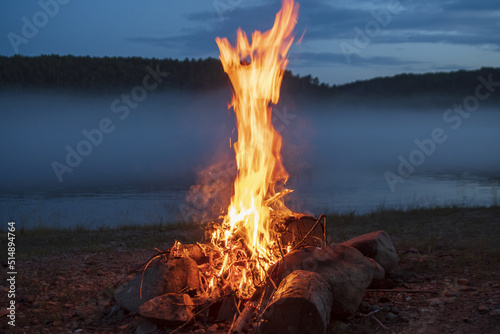 the flame of a campfire on the shore