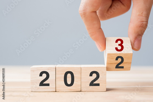 hand flip cube block 2022 to 2023 text on table. Resolution, review, strategy, end year, goal, business and New Year holiday concepts
