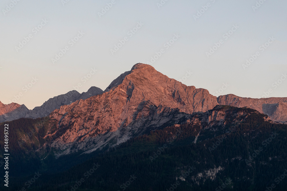 travel germany and bavaria, view at the mountain Hoher Goell at sunrise, dark trees in the forground, Bavaria, Germany