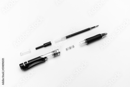 Disassembled gel automatic pen with a black gel rod on a white background