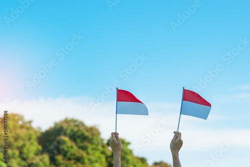 hand holding Indonesia flag on blue sky background. Indonesia independence day, National holiday Day and happy celebration concepts
