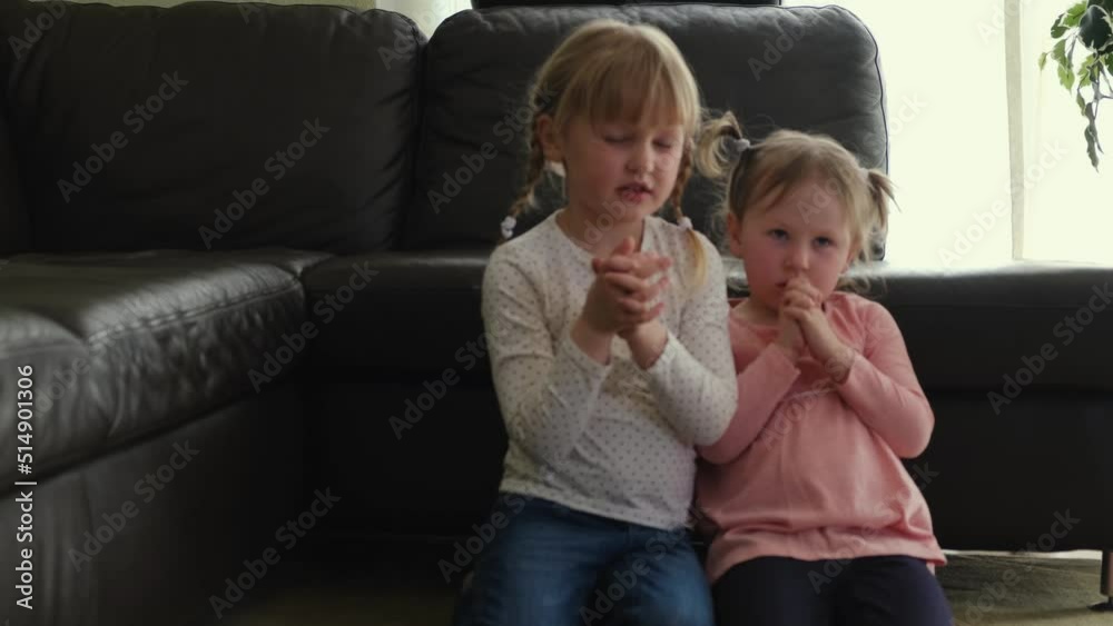 Little girls are praying to God in the living room crossed their arms