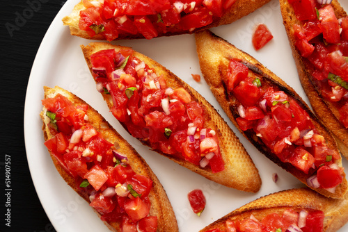 Homemade Italian Tomato Bruschetta with Basil on a Plate, top view.  Flat lay, overhead, from above. © Liudmyla