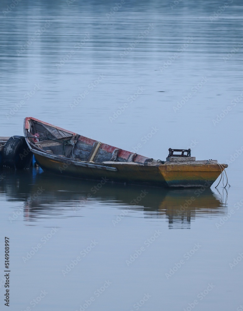 Obraz premium an old rowing fishing boat on the river