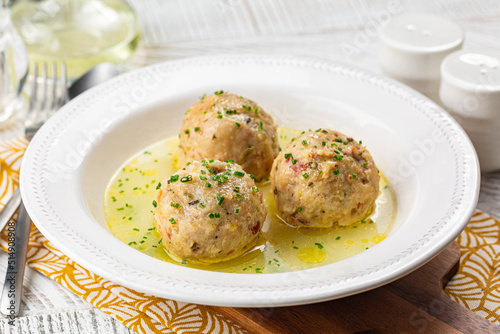 Canvastavla Canederli or Knödel in broth with green onion, typical pasta or dumplings for Alps, Alto Adige, German, Italian, Austrian cuisine
