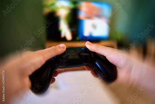Boy playing video game on console with joyctick gamepad in his hand, motion blur effect. Online entertainment and leisure activity. Gambling addiction