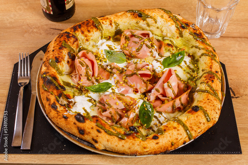 Pizza Napoletana Gourmet con crema di pistacchio di bronte, mortadella bolognese, granella di pistacchio di bronte, stracciatella fresca, feste di limone e basilico fresco photo