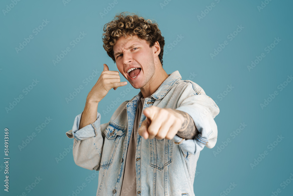 Young excited man gesturing and pointing finger at camera Young excited man gesturing and pointing finger at camera