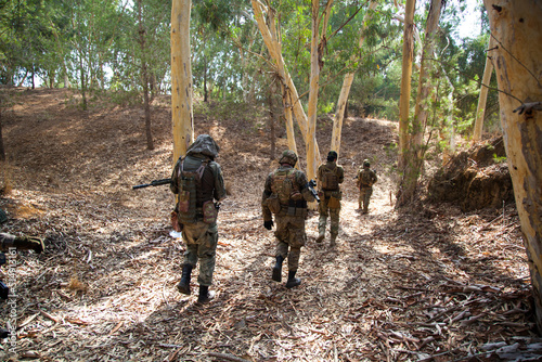 A detachment of the military goes through the forest with weapons to the advantage. The movement of a military detachment in the forest. Airsoft players change offensive position