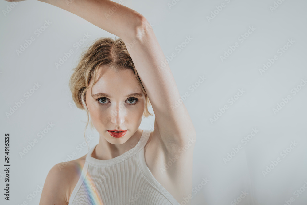 Confident woman showing armpit against white background Confident woman showing armpit against white background