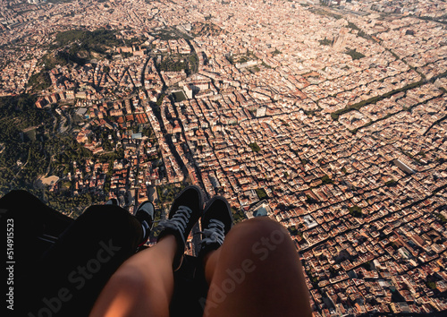 Spain, Catalonia, Barcelona, Personal perspective of young woman riding helicopter over densely populated residential district photo