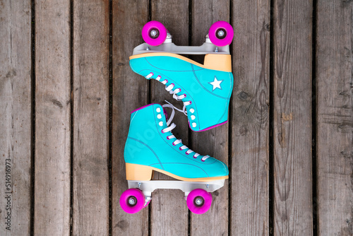 Multi colored roller skates on floorboard photo