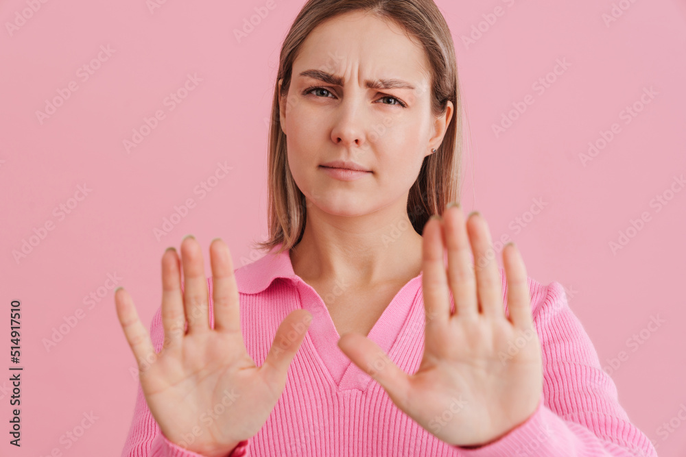 Young upset woman wearing shirt frowning and doing stop gesture Young upset woman wearing shirt frowning and doing stop gesture