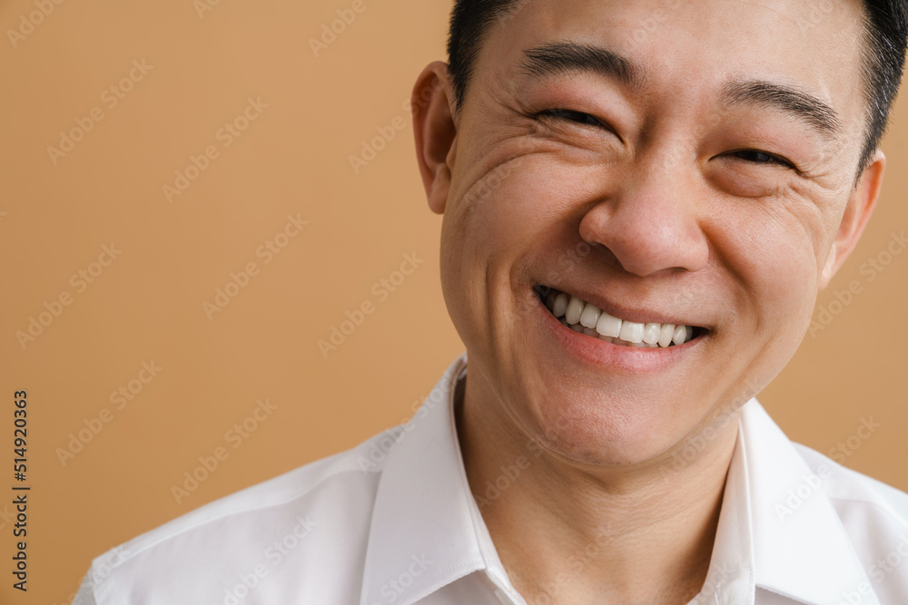 Brunette adult asian man wearing shirt laughing at camera Brunette adult asian man wearing shirt laughing at camera