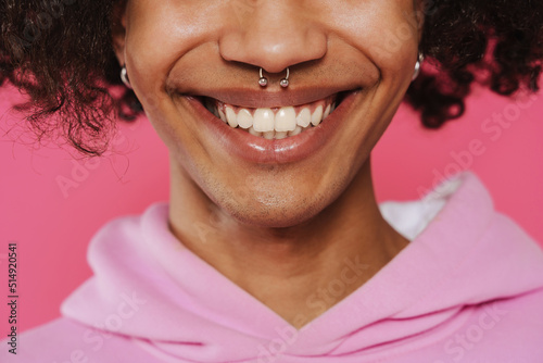 Young caribbean man with piercing smiling and looking at camera