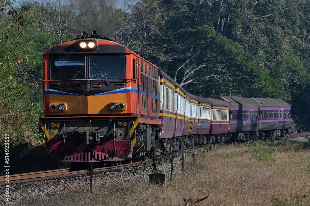 Obraz premium Thai passenger train by diesel locomotive on the railway.