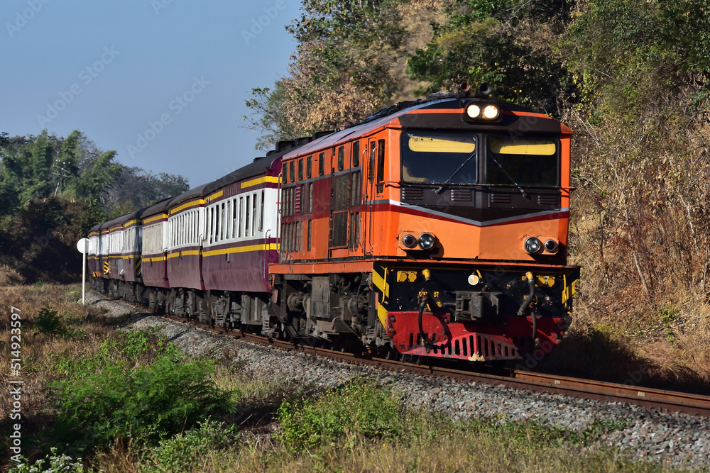 Thai passenger train by diesel locomotive on the railway.