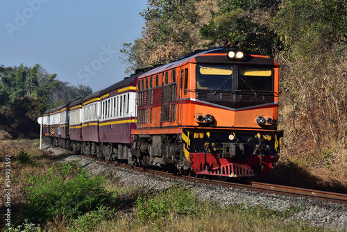 Thai passenger train by diesel locomotive on the railway.